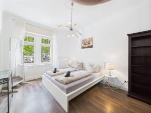 a white living room with a couch and a window at Zentrales Apartment im Westend I Küche I Balkon I für bis zu 4 Personen in Wiesbaden