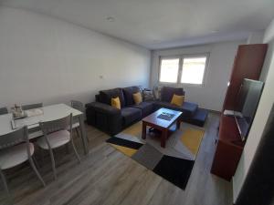 a living room with a couch and a table at Home from home in Noya
