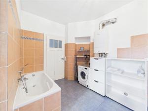 a bathroom with a tub and a washing machine at Zentrales Apartment im Westend I Küche I Balkon I für bis zu 4 Personen in Wiesbaden +12 photos