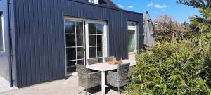 a patio with a table and chairs in front of a building at Foijingstate in Kollumerpomp