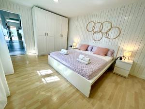 a bedroom with a large bed with pink pillows at GATU Villa Serena piscina privada mayores de 25 años y familias in Chiclana de la Frontera