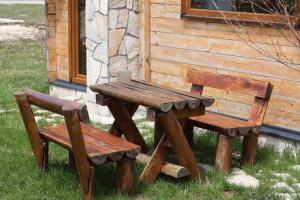 a wooden picnic table and two chairs next to a building at Portes du Soleil - Zabljak in Žabljak