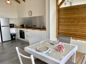 a dining room with a white table and chairs at Vanille, à proximité des plages, idéalement situé pour visiter la Guadeloupe in Le Gosier