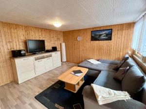 a living room with a couch and a tv at Bungalowdorf Briesensee in Neu Zauche