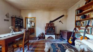 a living room with a desk and a wood stove at Off-grid Eco Farm Dolinka in Kozelník