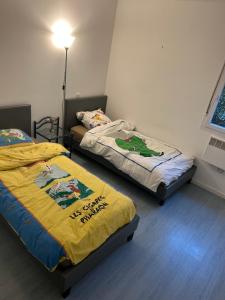 two beds sitting in a room with at Appartement deux chambres jardin parking in Portet-sur-Garonne