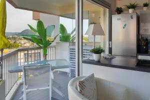 a balcony with a blue table and a refrigerator at Charming studio - 2 pers close to Cannes in Mandelieu-La Napoule