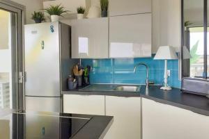 a kitchen with white cabinets and a refrigerator at Charming studio - 2 pers close to Cannes in Mandelieu-La Napoule +7 photos