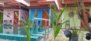 Ban Lao Suan Kluaiเอสบีพูลวิลล่า的一座房子前面有游泳池和植物