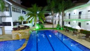 a hotel with a large swimming pool at night at Valentim Palace Hotel in Valentim Gentil