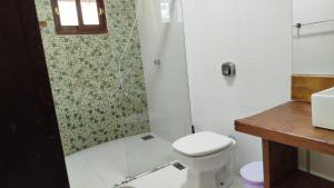 a bathroom with a toilet and a glass shower at Suites da Gladys in Foz do Iguaçu +15 photos