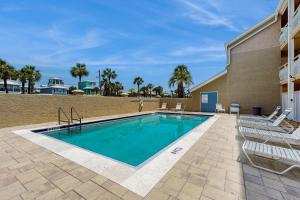Una piscina con tumbonas al lado de un edificio. en Crystal Villas, en Destin