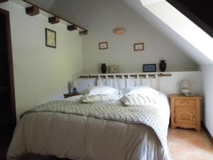 a bedroom with a white bed in a attic at La longére du Lesty in Ambon