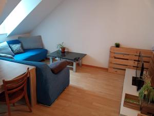 a living room with a blue couch and a table at Gemütliche Dachwohnung in St. Gallen