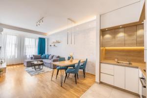 a kitchen and living room with a table and chairs at Arena BIG Luxury Apartments in Novi Sad