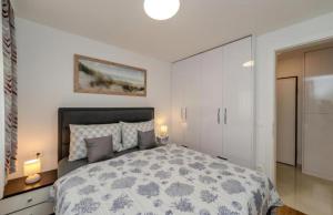 a bedroom with a large bed and white cabinets at Villa Oliva Petrcane in Petrcane