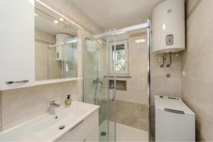 a bathroom with a glass shower and a sink at Villa Oliva Petrcane in Petrcane +20 photos