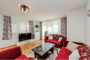 a living room with red furniture and a tv at Villa Oliva Petrcane in Petrcane