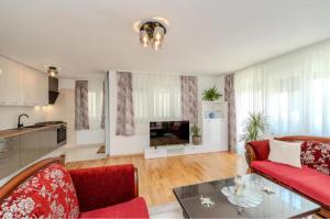 a living room with a red couch and a table at Villa Oliva Petrcane in Petrcane