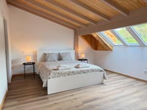 ein Schlafzimmer mit einem großen Bett in einem Zimmer mit Fenstern in der Unterkunft Villa Ribeirinho Stays - 4 Bedrooms in Porto