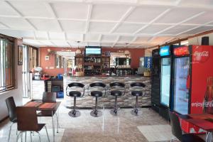 a bar with stools in front of a counter at Biyem Hotel in Kampala