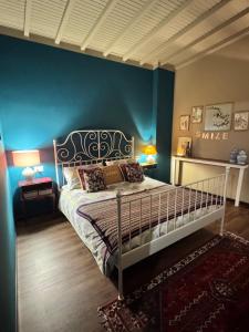 a bedroom with a bed with a blue wall at LA MAGIA nel BORGO in Fezzano