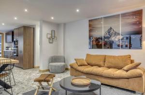 a living room with a couch and a table at Huxa Appt Megève Centre in Megève