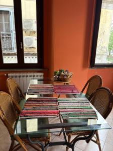 a glass table with mats on top of it at Casa accogliente sul naviglio in Milan +8 photos