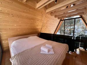 a room with a bed with two towels on it at Hedonizam in Zmajevac