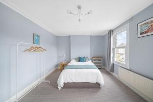 a white bedroom with a bed and a window at Beautiful Large Bedrooms in South Norwood