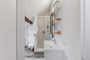 a white bathroom with a sink and a toilet at RICLS Apartmenthaus Wurmberg - BRIGHT Collection in Wurmberg +150 photos