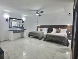 a bedroom with two beds and a ceiling fan at Newly renovated & furnished apartment in Cozumel +21 photos