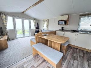 a kitchen with a wooden table and a counter at Beautiful 6 Berth Caravan With Stunning Sea Views In Suffolk Ref 68029Cr in Lowestoft