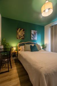 a bedroom with a bed and a green wall at Homestay Glan Llyn in Newport