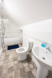 a bathroom with a white toilet and a sink at Cosy Llandudno Apartments in Llandudno +38 photos