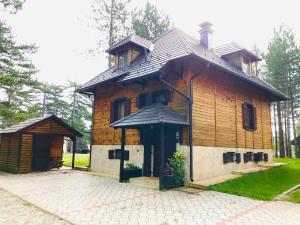 a small wooden house with a roof at vila Family apartman 2 in Kaludjerske Bare +2 photos