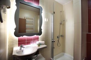 a bathroom with a sink and a shower with a mirror at Hotel Raca in Sesvete