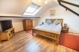 a bedroom with a bed and a flat screen tv at Cosy Llandudno Apartments in Llandudno