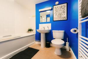 ein blaues Badezimmer mit Toilette und Waschbecken in der Unterkunft Trendy Accommodation in Arsenal in London + 52 Fotos