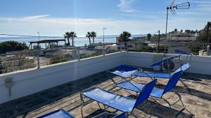 three blue chairs sitting on a balcony overlooking the ocean at Villa Simonetta in Alliste