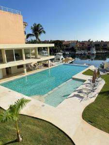 une grande piscine devant un immeuble dans l'établissement Azure Caribbean Green Spirit, à Puerto Aventuras