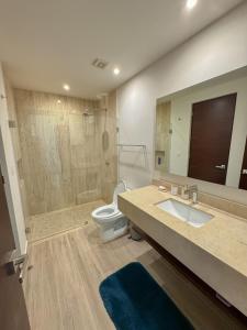 une salle de bain avec un lavabo, des toilettes et un miroir dans l'établissement Azure Caribbean Green Spirit, à Puerto Aventuras