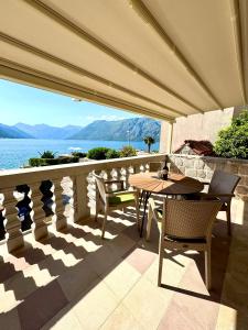 a patio with a table and chairs and a view of the water at Apartments Radonicic in Kotor