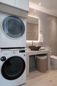 a washing machine in a bathroom with a sink at BLUE VILLA Sifnos in Kamarai