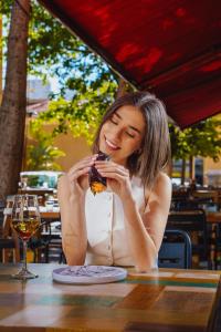 a woman sitting at a table eating a piece of food at Monot Suites in Beirut +40 photos