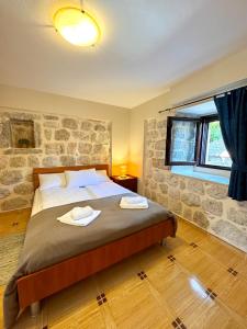 a bedroom with a large bed with a stone wall at Apartments Radonicic in Kotor