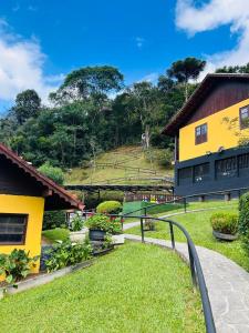 a view of a house with a green yard at Pousada Águas Claras in Visconde De Maua