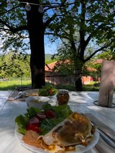 a table with a plate of food and a salad at Ostojino osoje in Šarani