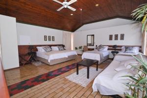 una grande camera con due letti e un divano di The Hellens Guest House a Pretoria