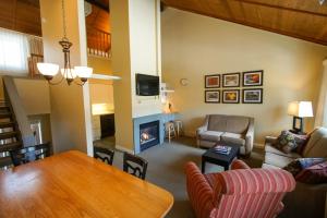 a living room with a table and a fireplace at The Villages of Loon Mountain Fixed in Lincoln